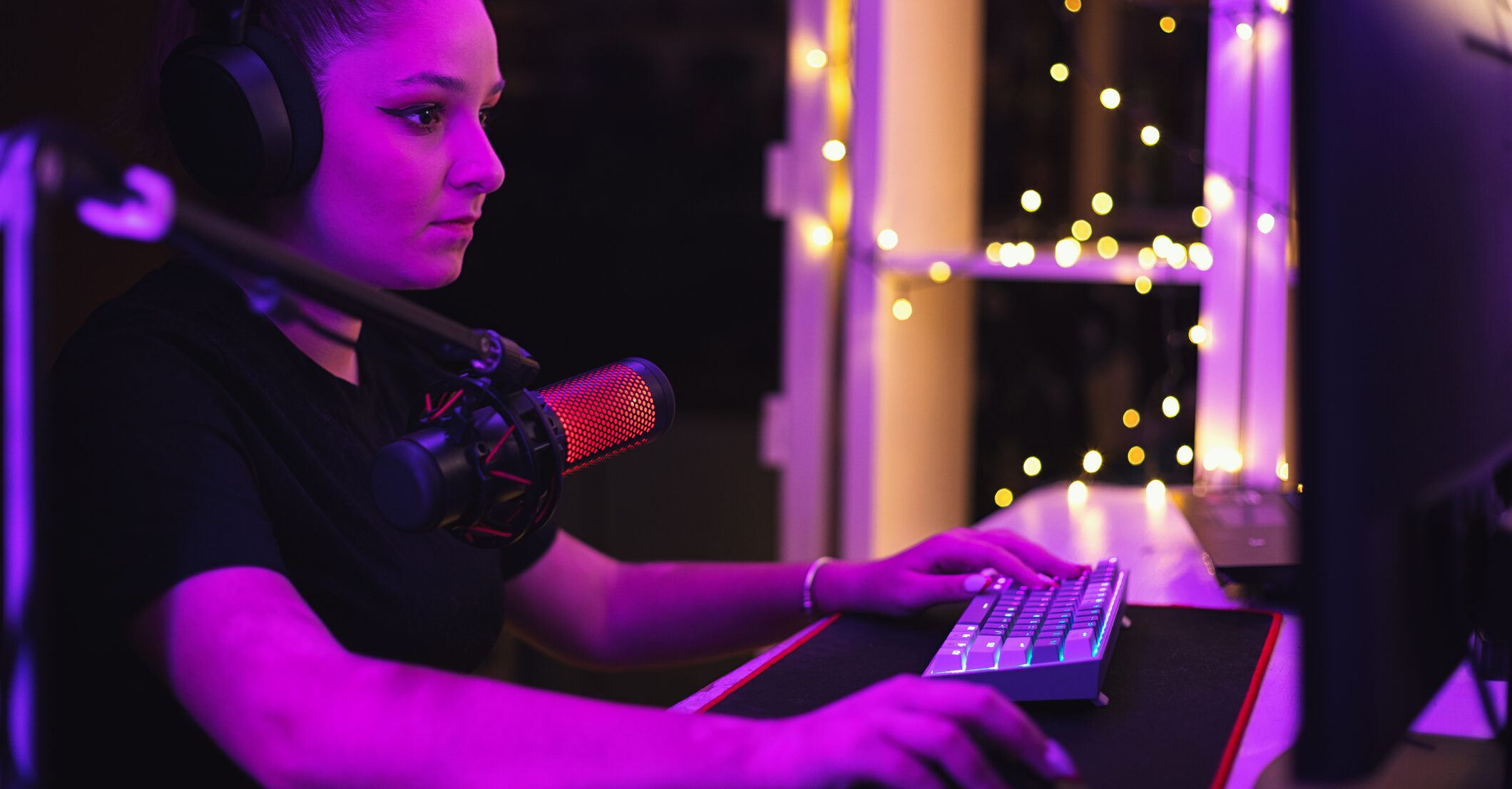 Young female gamer participating in a competitive video game with sheer concentration and streaming at home