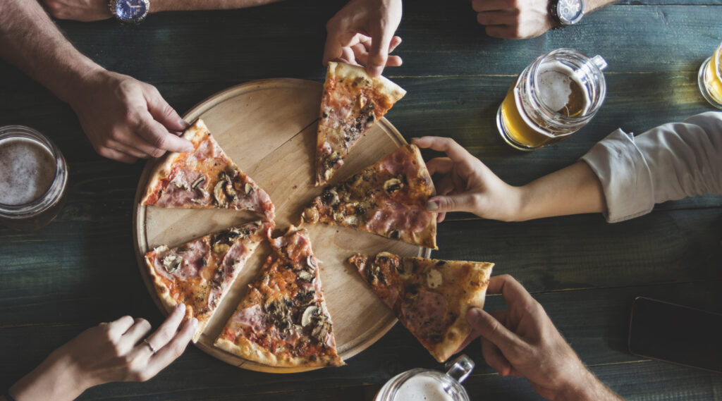 Friends having pizza in a restaurant. Top view.