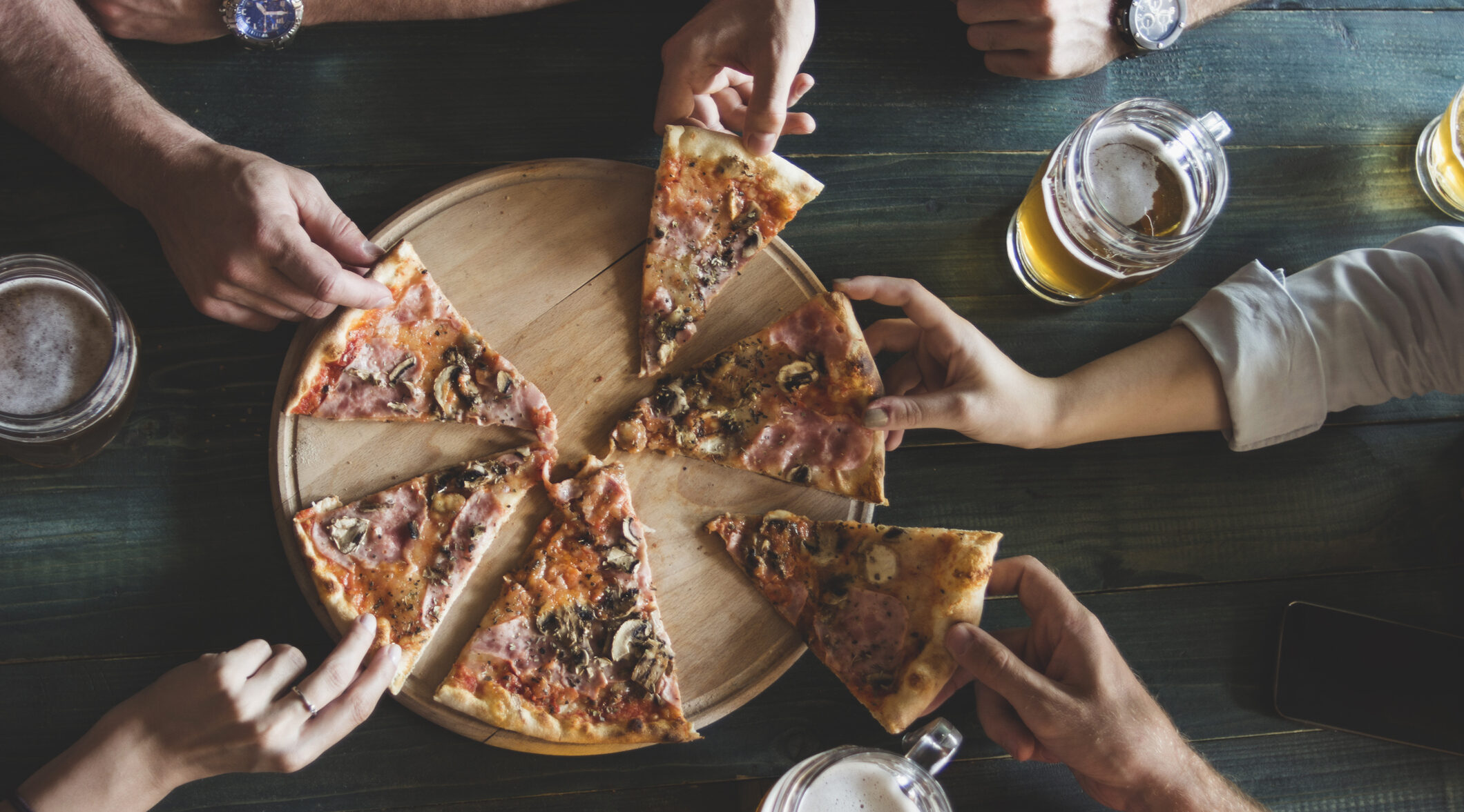 Friends having pizza in a restaurant. Top view.